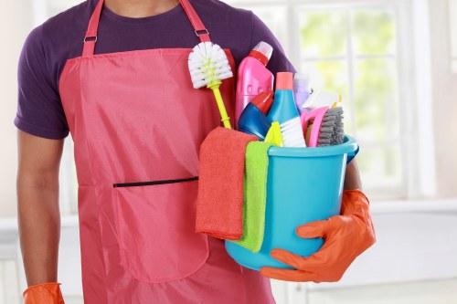 Cleaner preparing carpet cleaning equipment safely before work begins
